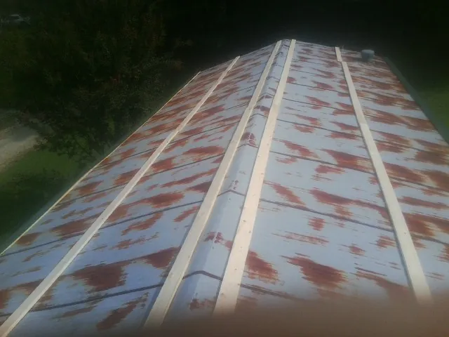 Rusted metal roof panels with new wood purlins before replacement — Storm Damage Roof Repair in Paul Smiths by Roofing Brothers